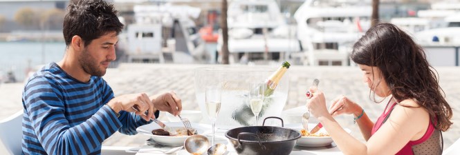 Couple eating paella in the harbour