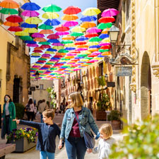 Two children with their mother walking through the Poble Espanyol in Barcelona